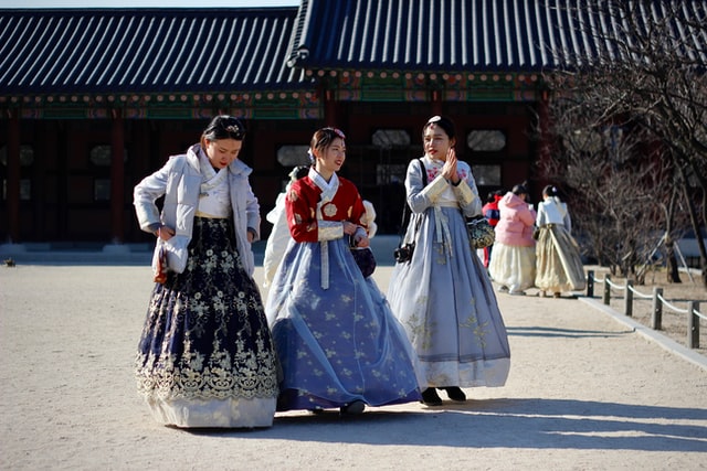 Three Chinese girls wearing their traditional clothing.